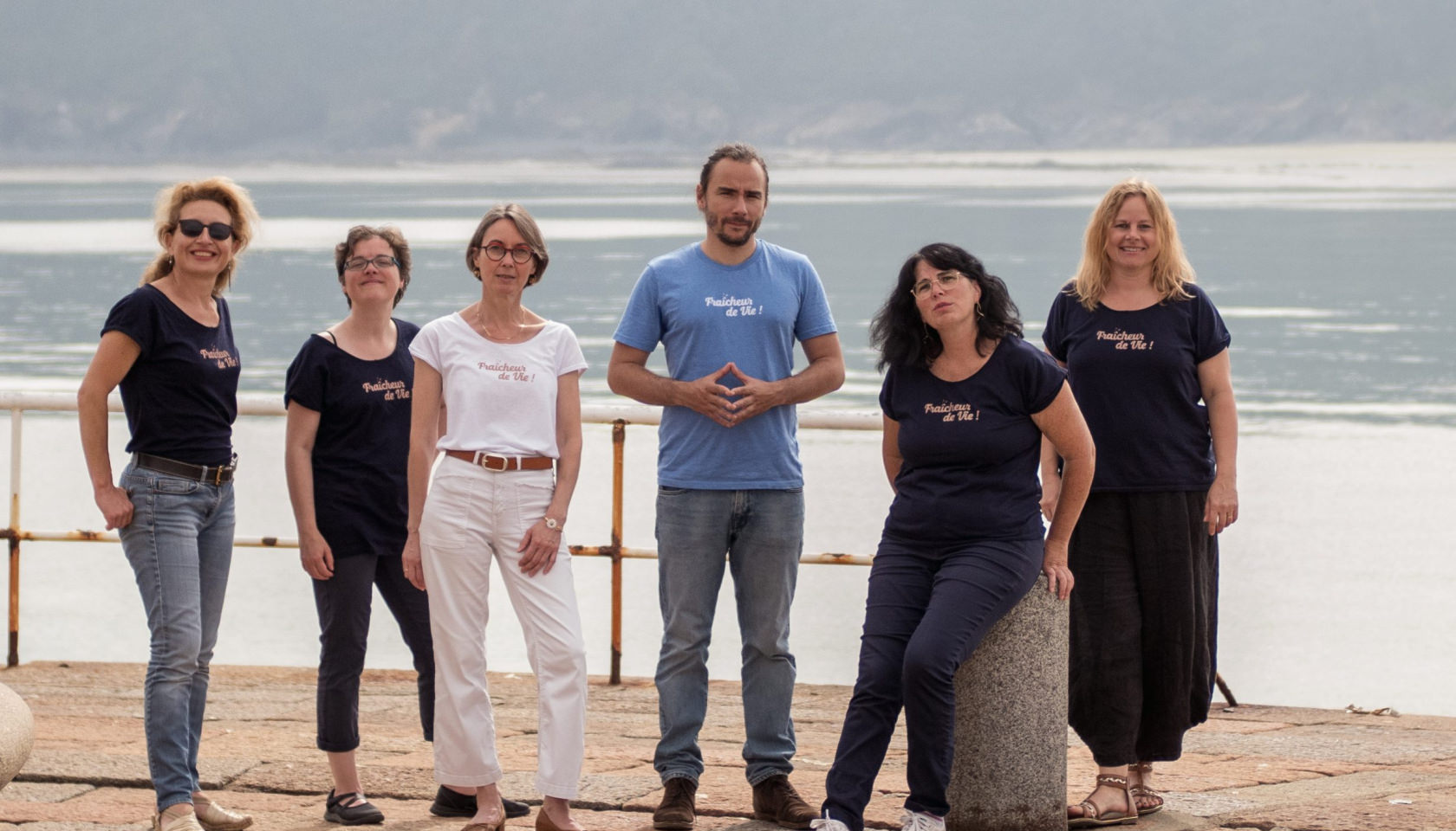 Panneau de personnes souriantes devant la mer à Binic, Étables-sur-Mer, Bretagne.